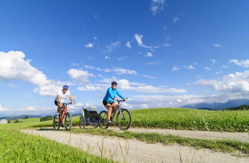 2 Personen auf Fahrrädern auf einem Radweg im Grünen